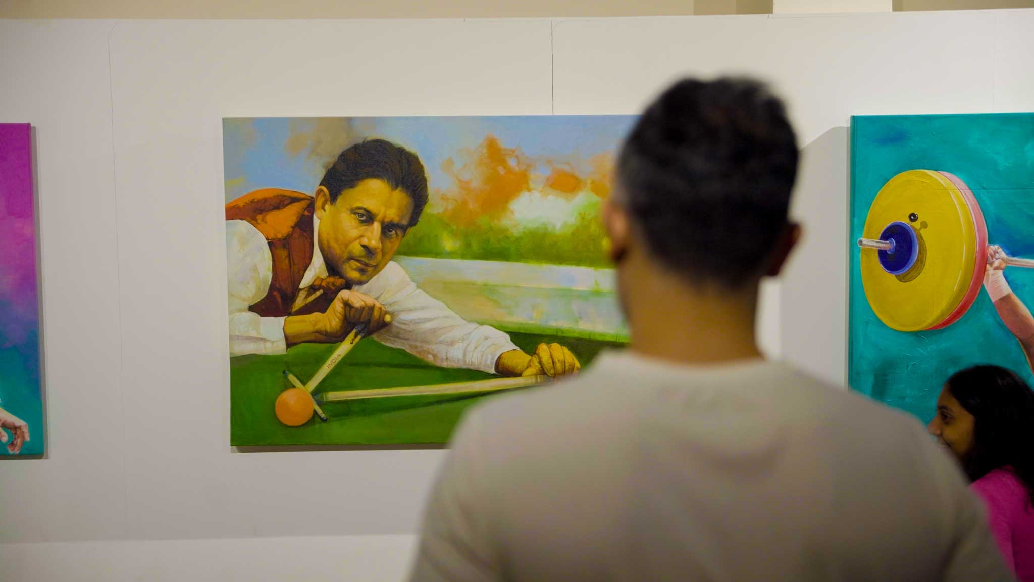 Man viewing a painting of a man playing billiards in an art gallery